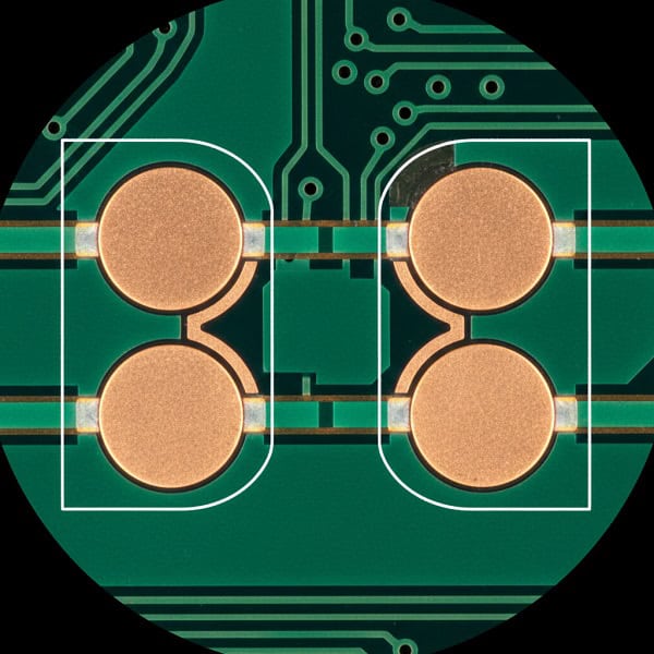 Macro view of PCB pads showing precise green solder mask dams and clearance to prevent bridging