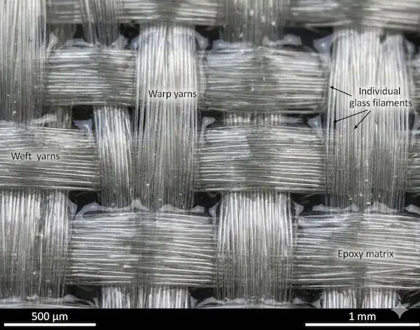 Microscopic view of prepreg fiberglass weave styles impregnated with epoxy resin for PCB fabrication.