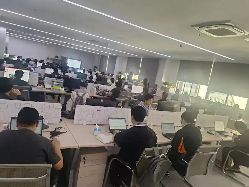 PCB engineering team at office workstations reviewing design files and production orders