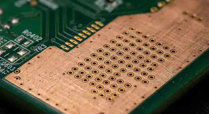 Dense stitching vias connecting a top layer PCB copper pour to the internal ground plane for EMI shielding cleanup
