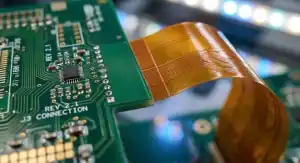 Macro photography of a hybrid rigid flex PCB showing the transition between green FR4 and flexible polyimide, highlighting the cost difference cleanup