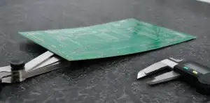 Inspector measuring PCB bow twist spec with feeler gauge on a granite inspection surface