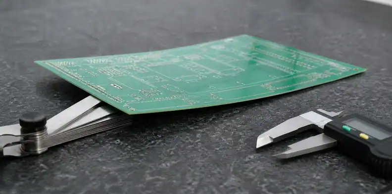 Inspector measuring PCB bow twist spec with feeler gauge on a granite inspection surface