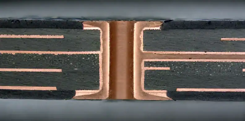 A manufacturing view of pTH hole-wall metallization showing a plated hole cross-section after drilling.