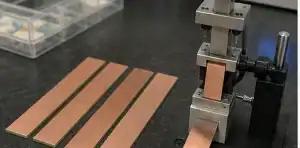 A test bench shows PCB copper peel strength review with copper-clad laminate samples and adhesion test fixtures.