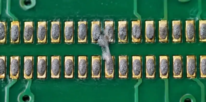 A paste smear connects neighboring pads before reflow.
